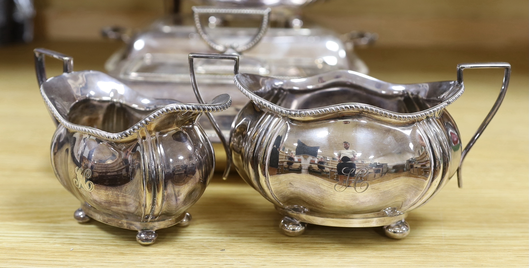 A group of silver plated items including a pair of three branched candlesticks, teapot, milk jug and sugar bowl, the largest 36cm high